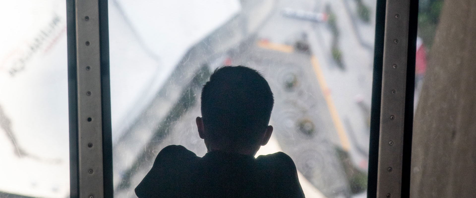 Child peering through the Glass Floor at the CN Tower