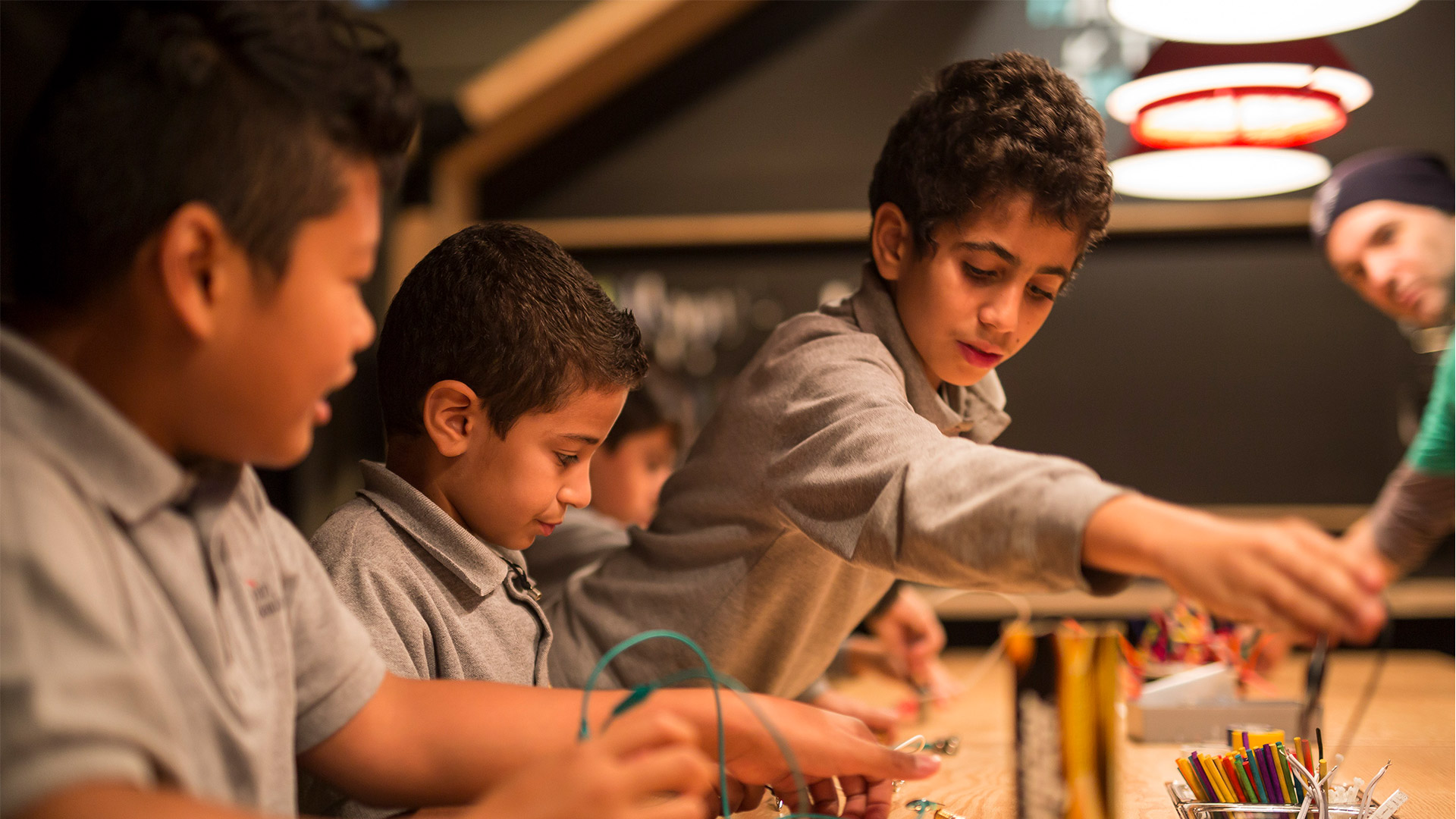 Three boys participate in an activity at the Montreal Science Centre