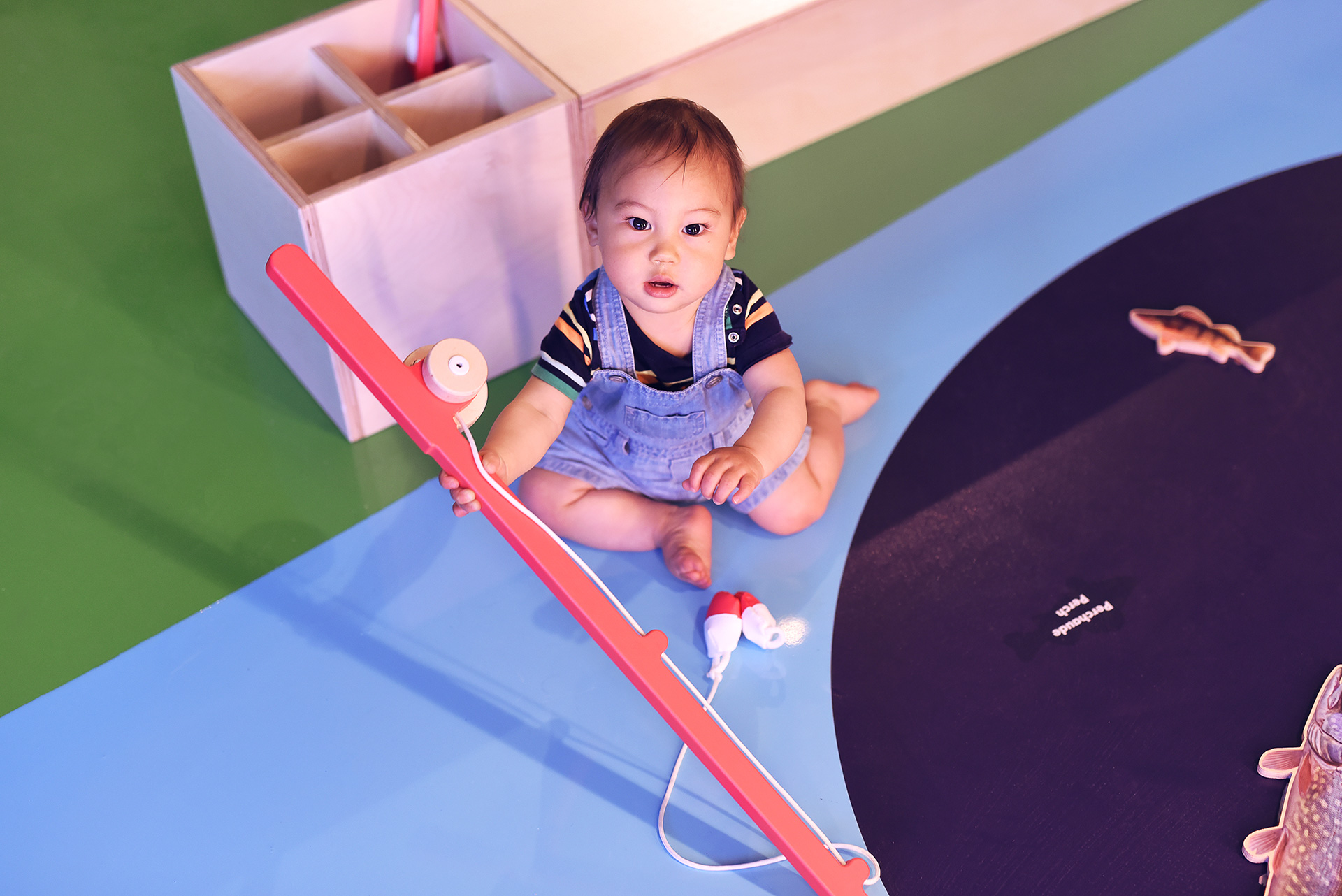 An infant at the Mini Mondo exhibit looks directly at the camera