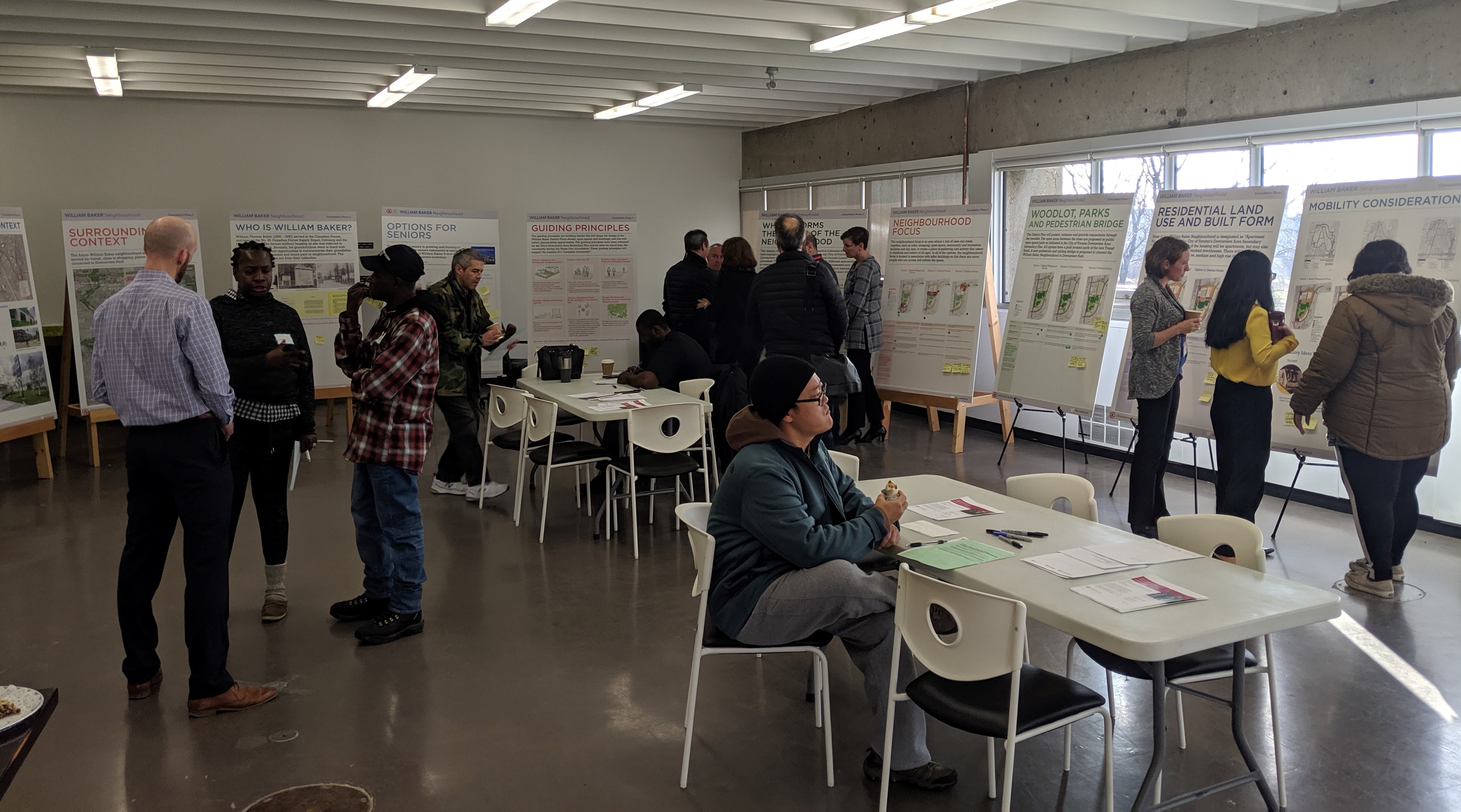A group of people review a series of presentation boards