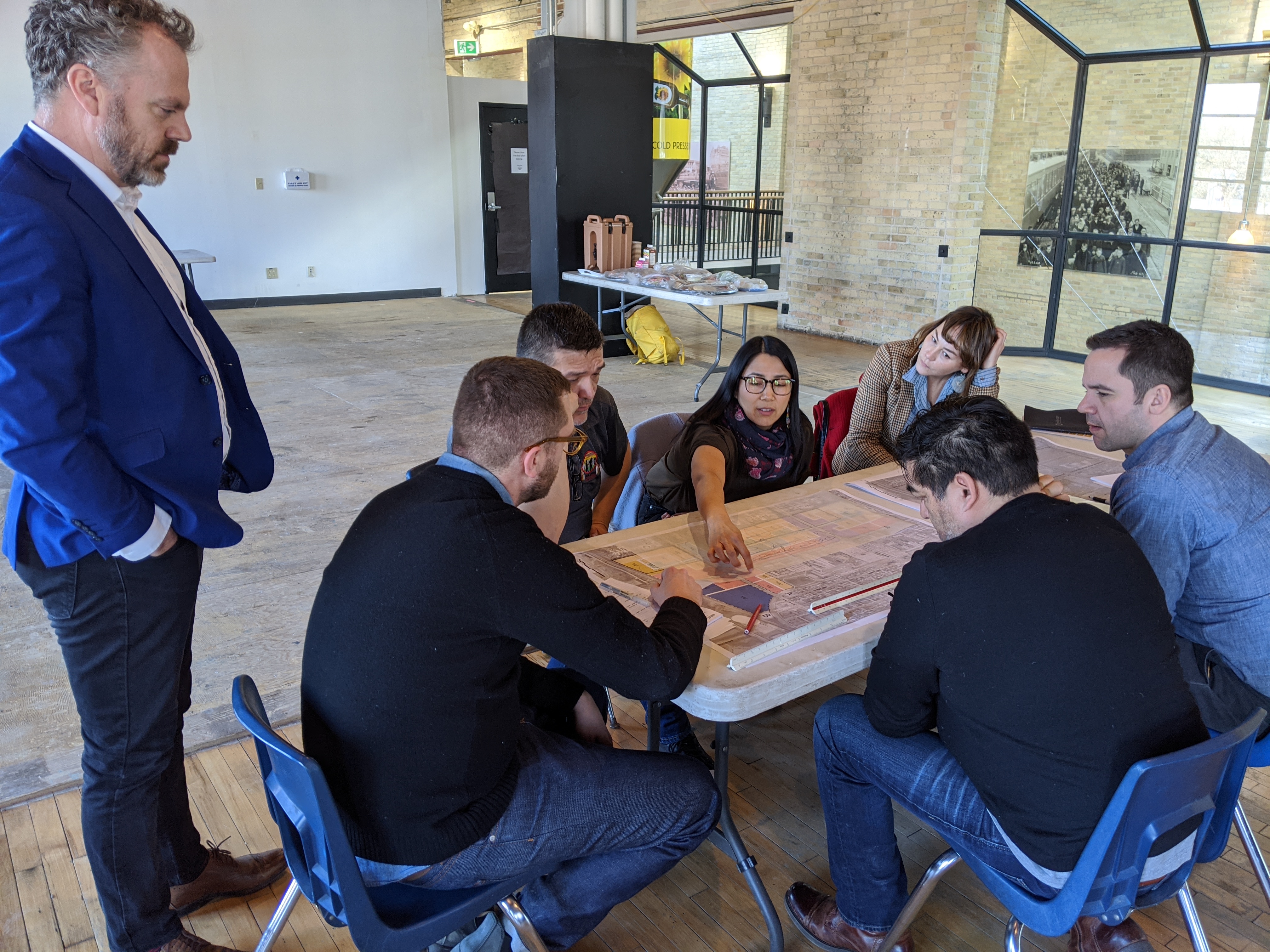 A group of people sit at a table during a meeting