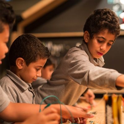Three boys participate in an activity at the Montreal Science Centre
