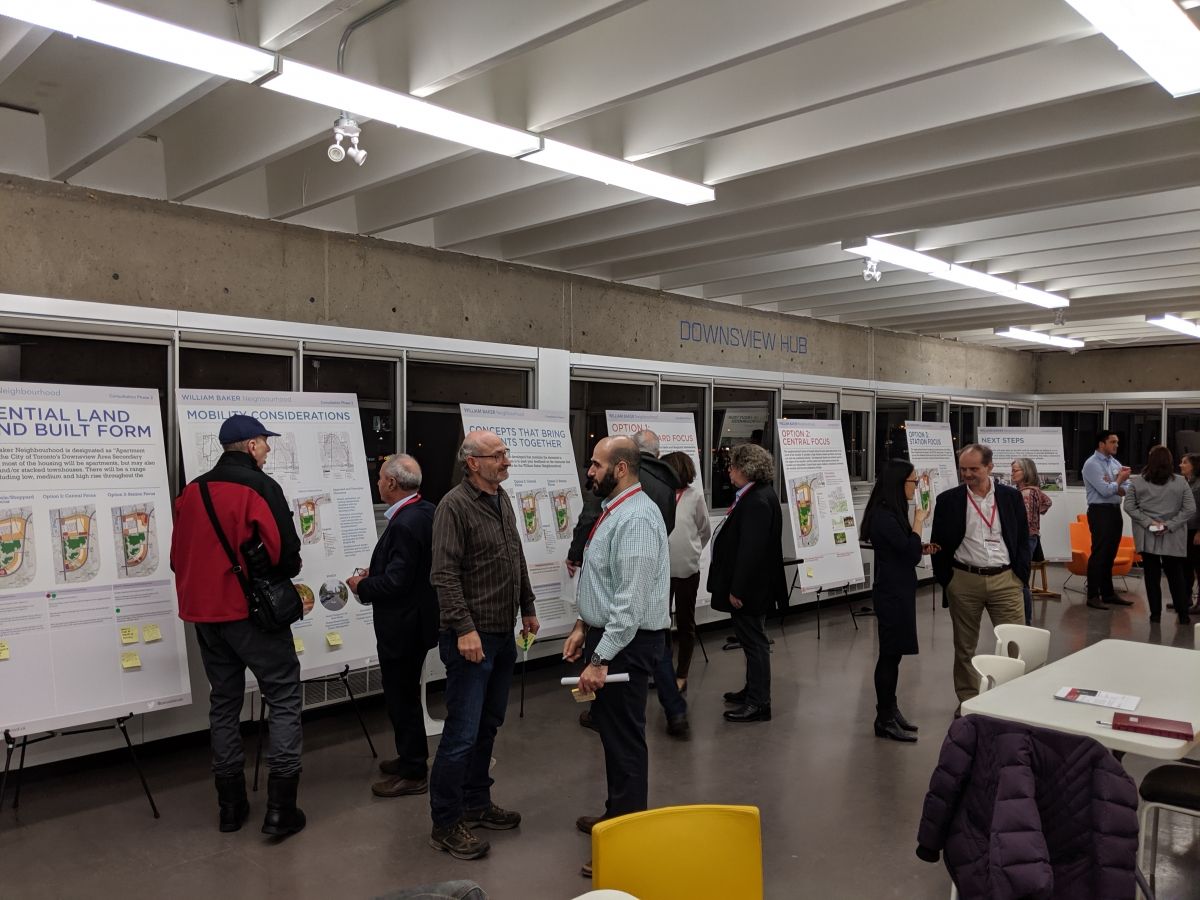 A group of people review a series of presentation boards