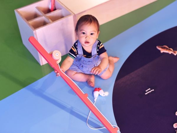 An infant at the Mini Mondo exhibit looks directly at the camera