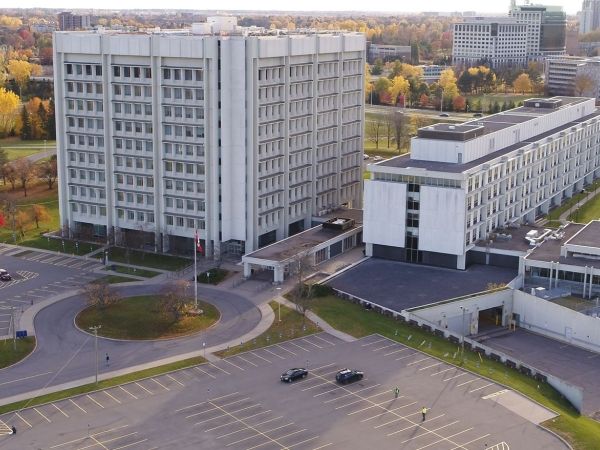 Two buildings and a large parking lot on the Confederation Heights property in Ottawa