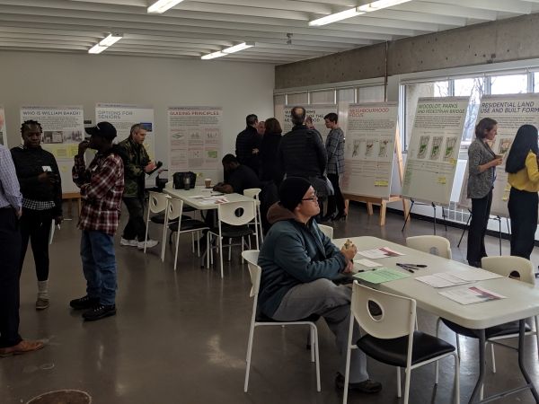 A group of people review a series of presentation boards